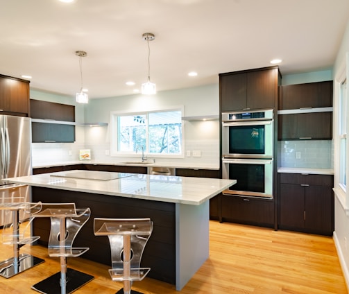 three clear glass bar stools