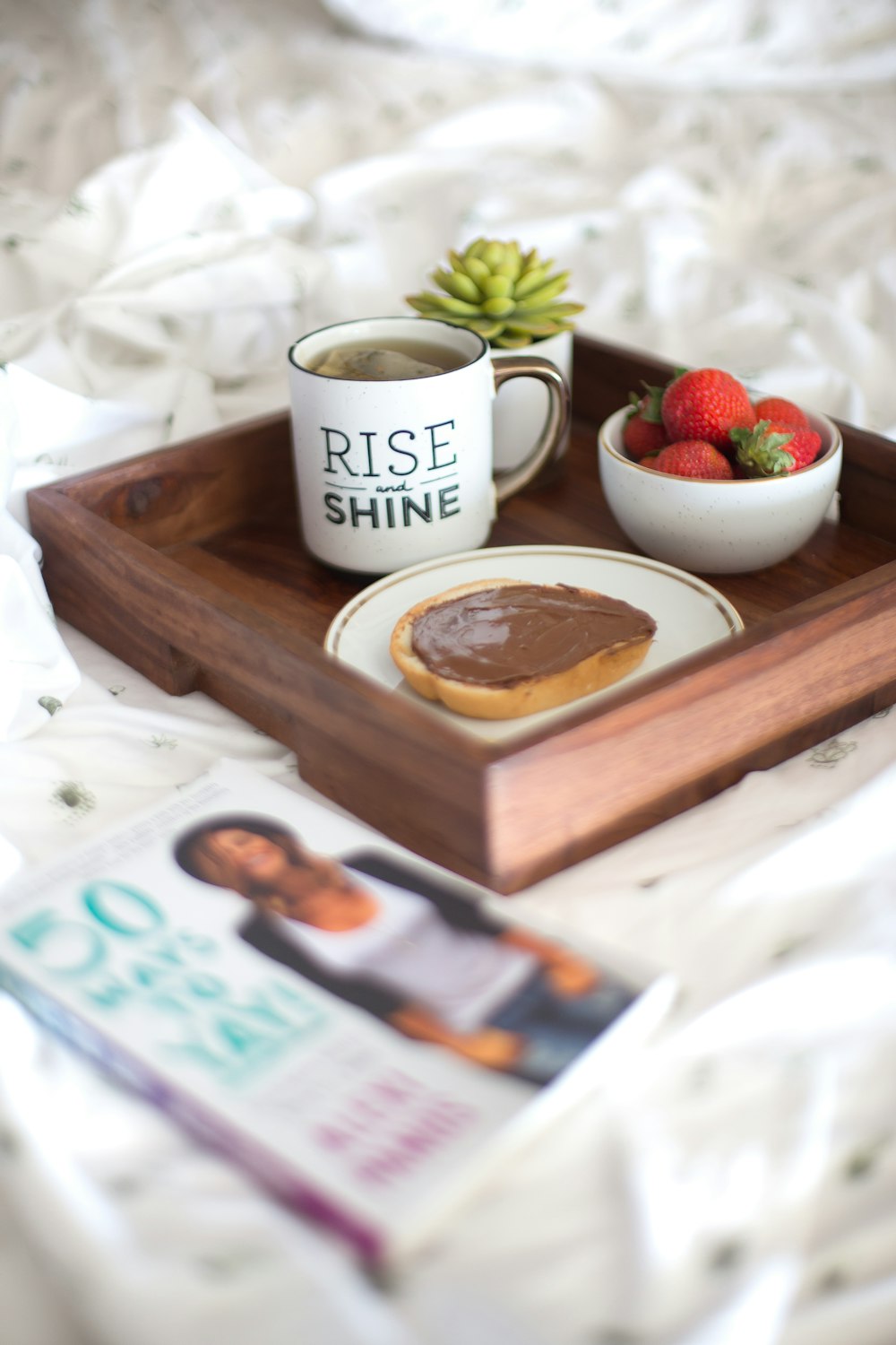 white Rise Shine ceramic mug on brown table
