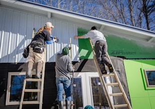 three person climbing on ladder