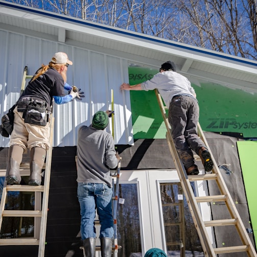 three person climbing on ladder