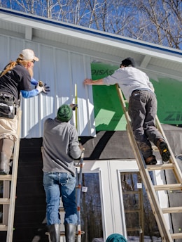 three person climbing on ladder