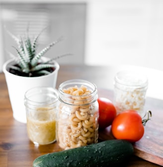 green cucumber near jars on table