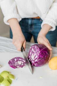 woman slicing purple vegetable