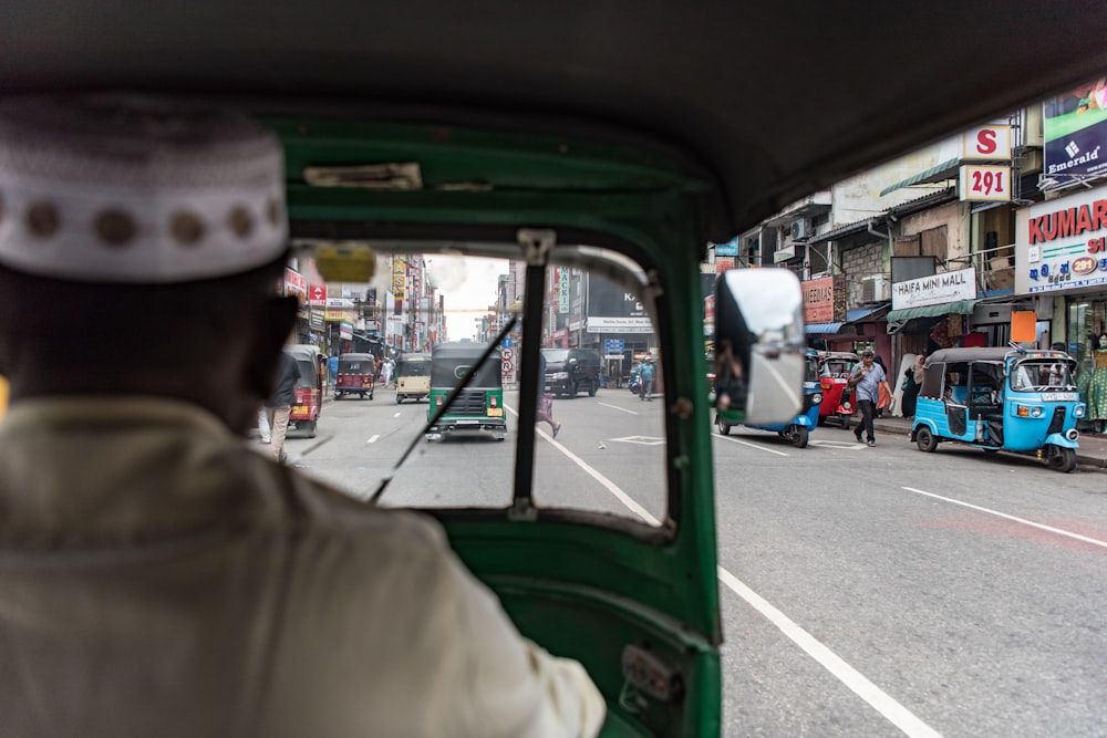 Hombre en verde motor rickshaw en carretera