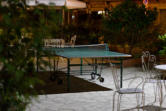 An elegant all-glass ping pong table bathed in soft ambient lighting inside a modern executive lounge.