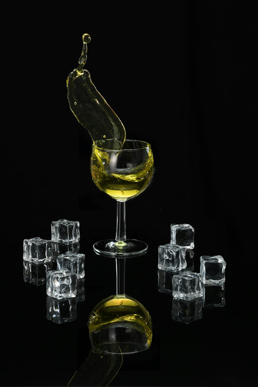 Bicchiere da vino trasparente riempito di liquido giallo