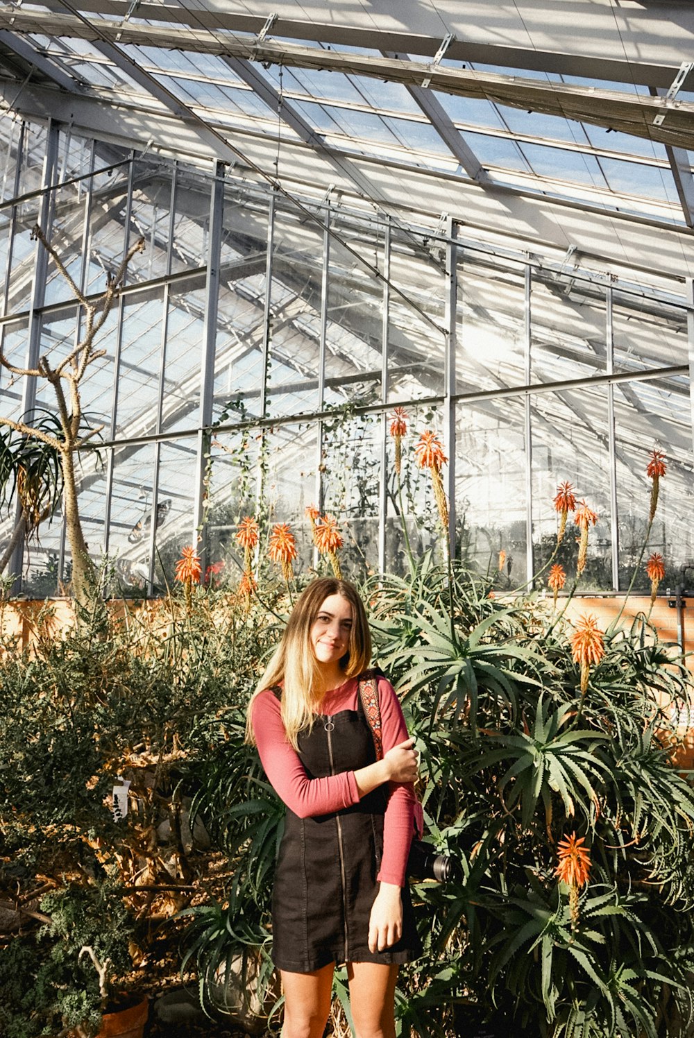 smiling woman standing near flower garden