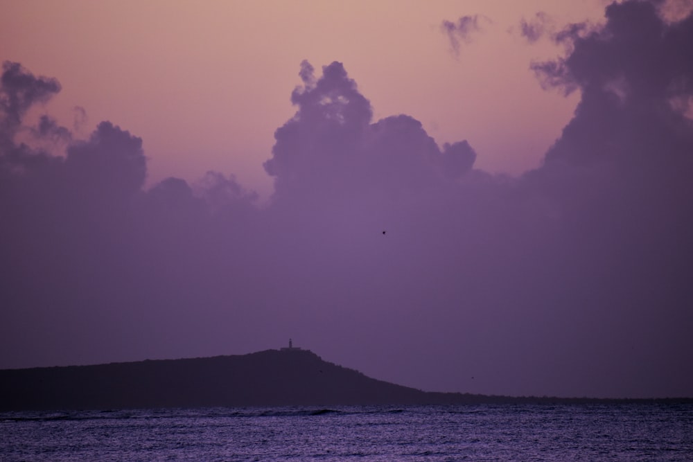 calm sea and mountain during daytime