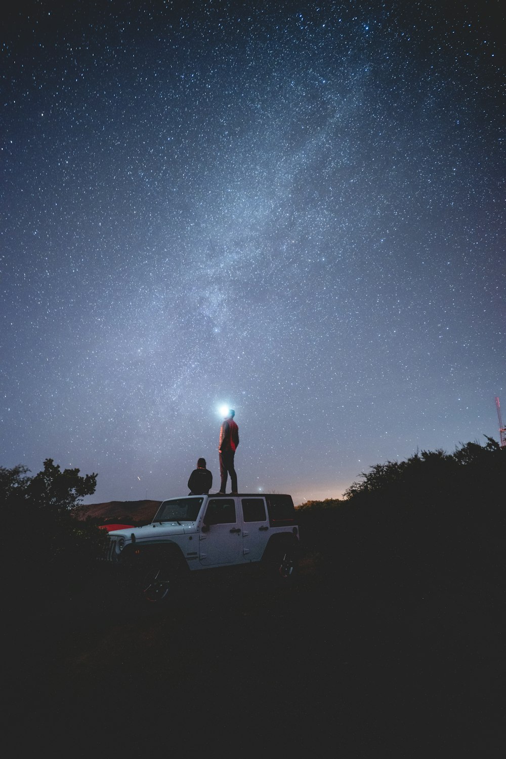 Dos personas en vehículo blanco por la noche