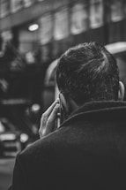 grayscale photo of man using smartphone