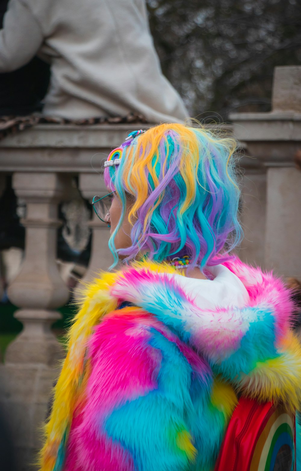 Selektive Farbfotografie einer Frau, die blauen, gelben und rosa Mantel und Haare trägt