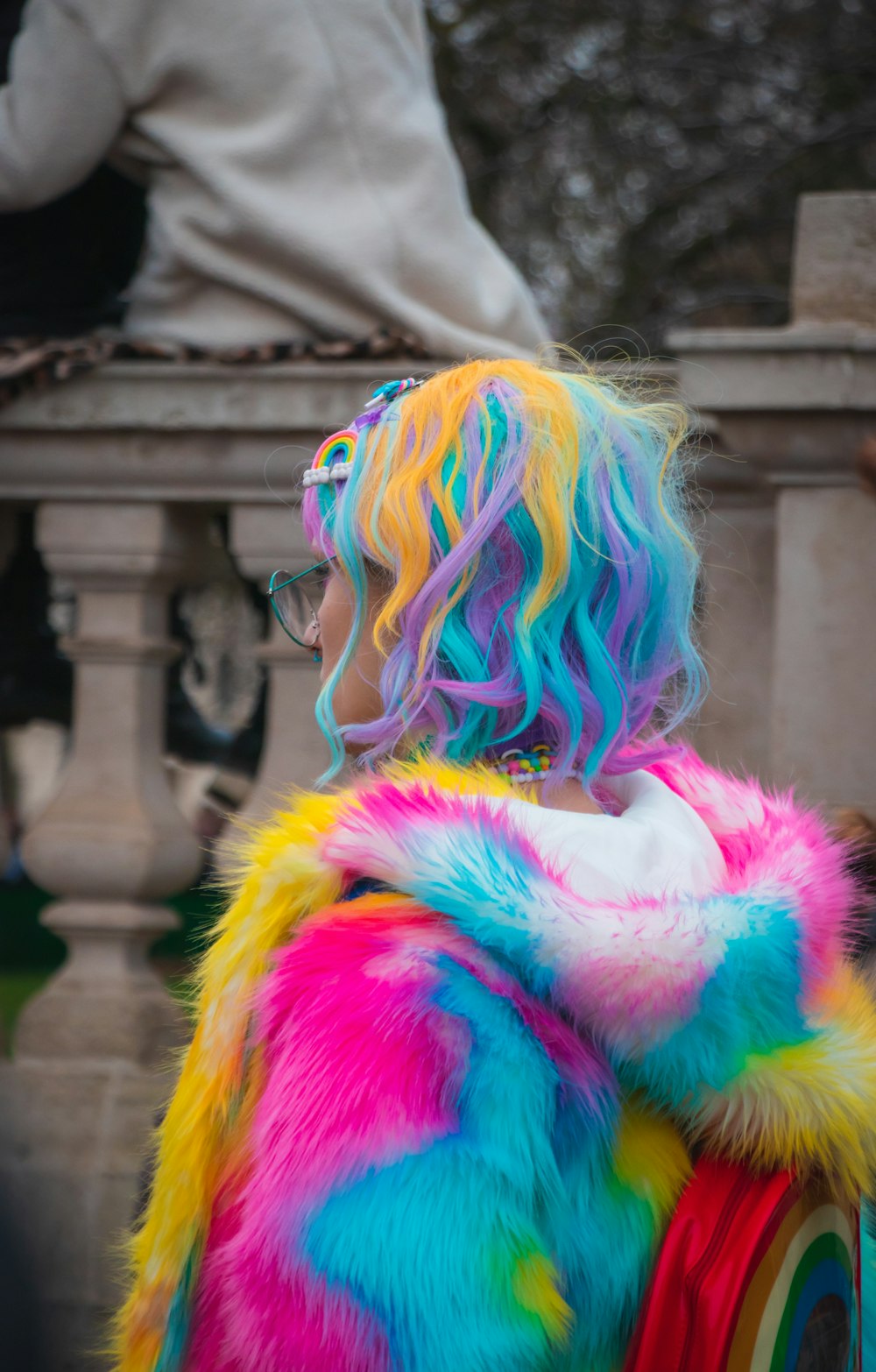 Fotografía selectiva en color de mujer con abrigo y cabello azul, amarillo y rosa