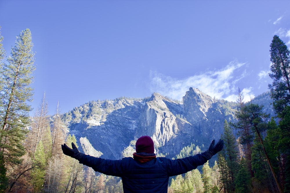 person standing in front of snow covered mountain during daytime