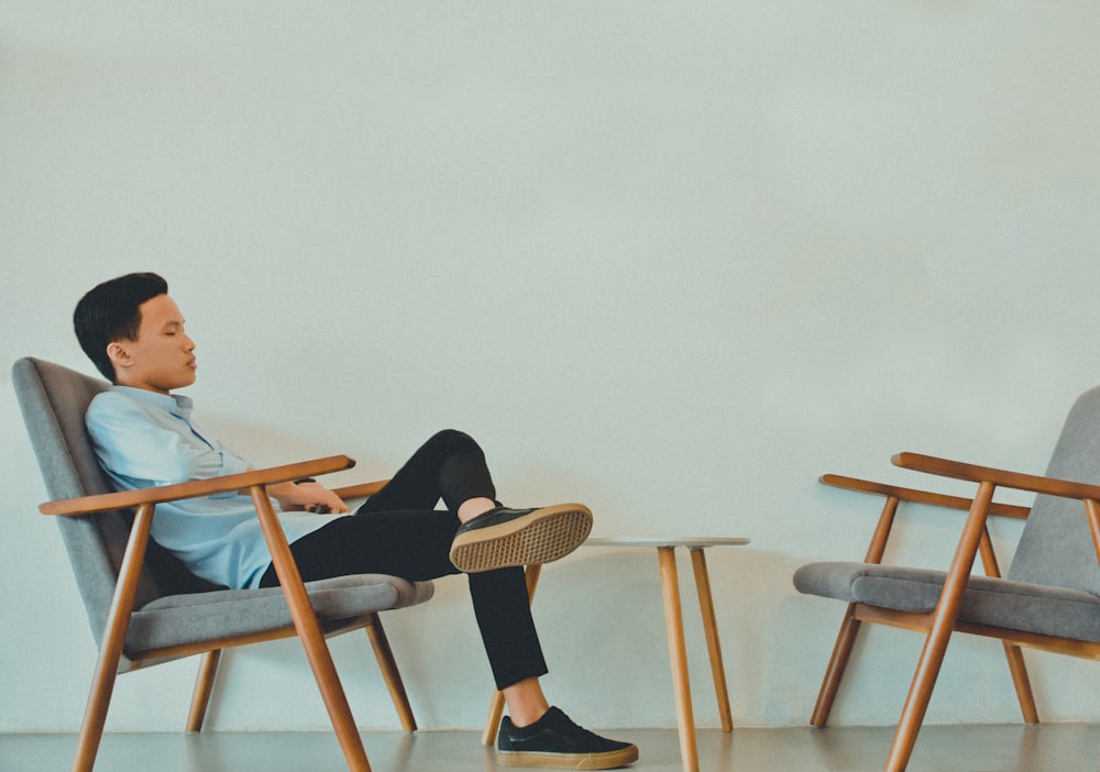 man sitting on gray fabric armchairs