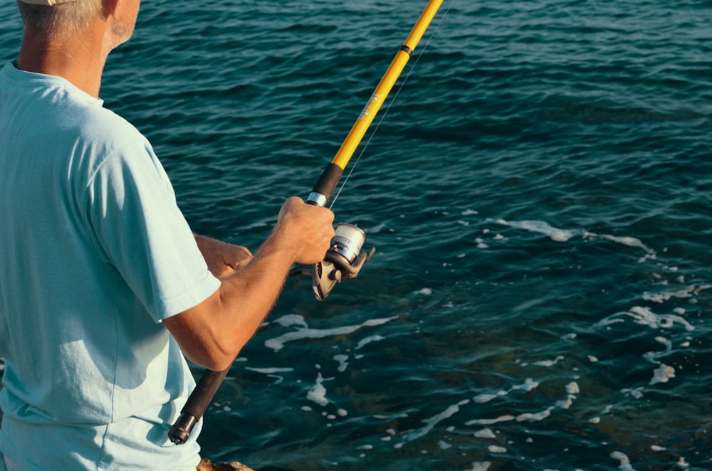 selective focus photography of man holding fishing rod
