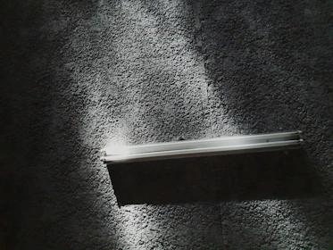 Close-up of a custom-designed lighting fixture casting cinematic shadows on textured walls.