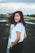 smiling woman standing on concrete floor in white t-shirt