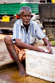 man wearing striped top holding styro ice box