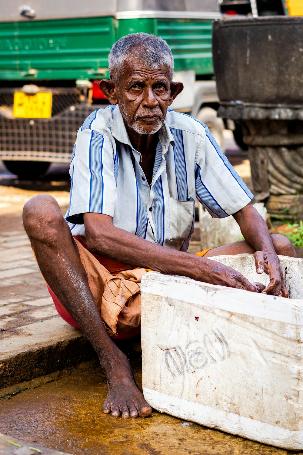 man wearing striped top holding styro ice box