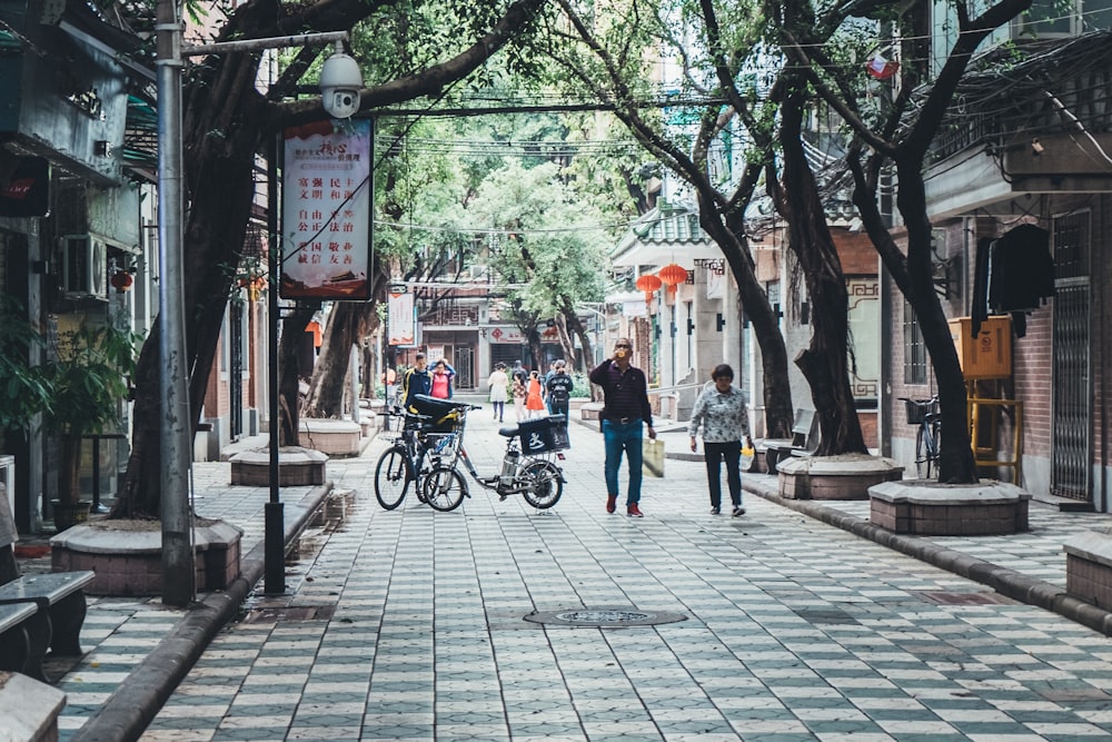 man standing beside bicycle