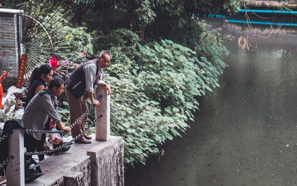 trois personnes regardant l’eau