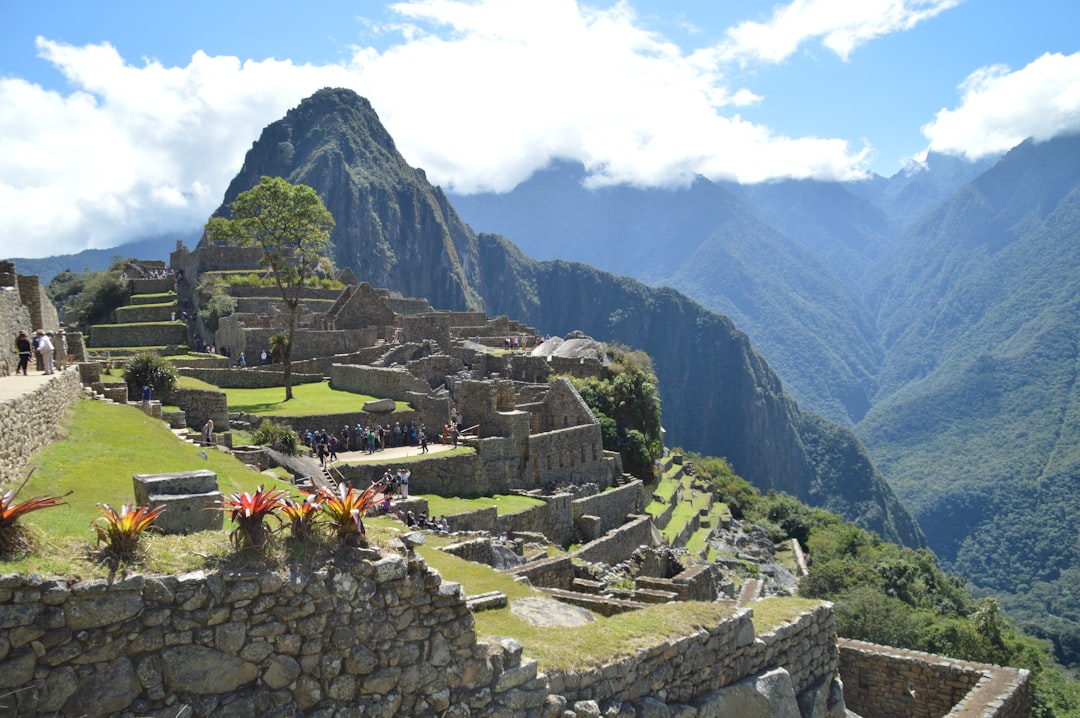 green and brown concrete building, Machu Picchu on a sunny day with a couple of clouds