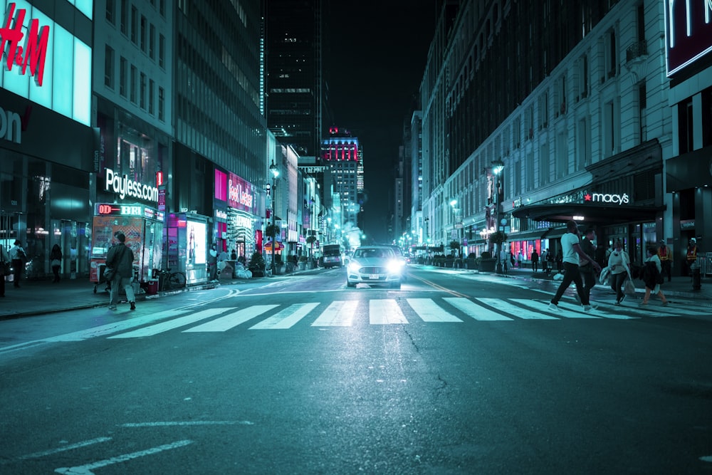 people walking on pedestrian near car