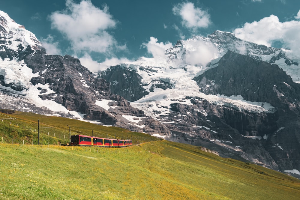 red train near mountain alps
