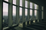 A bright and airy living space with large windows, showcasing a view of the city skyline.