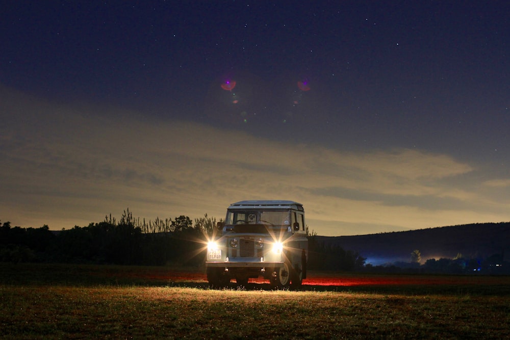 landscape photography of vehicle with turned-on headlights