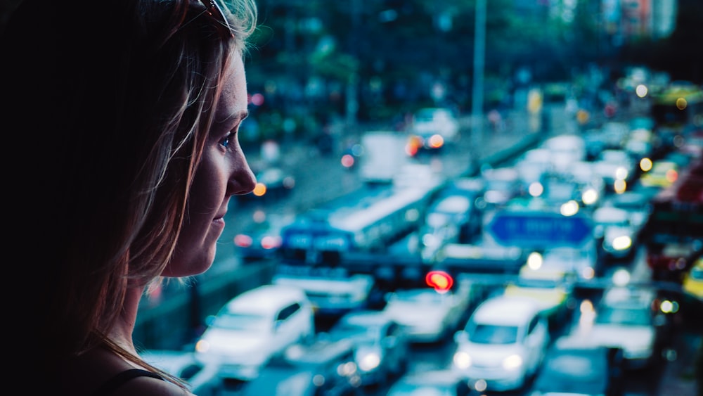 close-up photography of woman standing front of vehicles