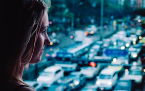 close-up photography of woman standing front of vehicles