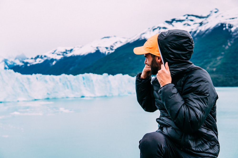 man surrounded by snow wearing black bubble jacket