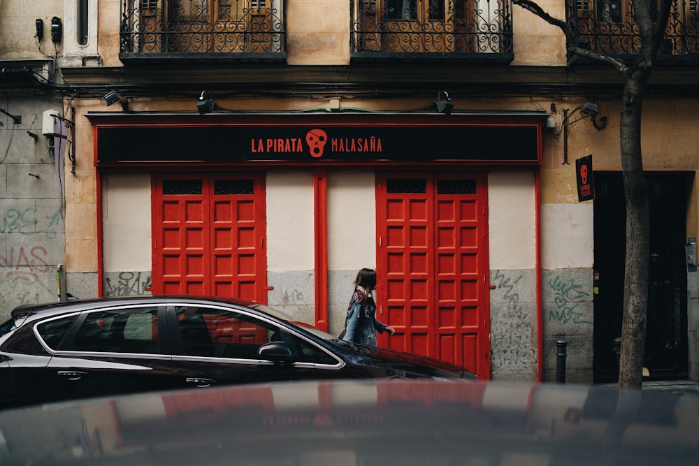 woman standing next to black car