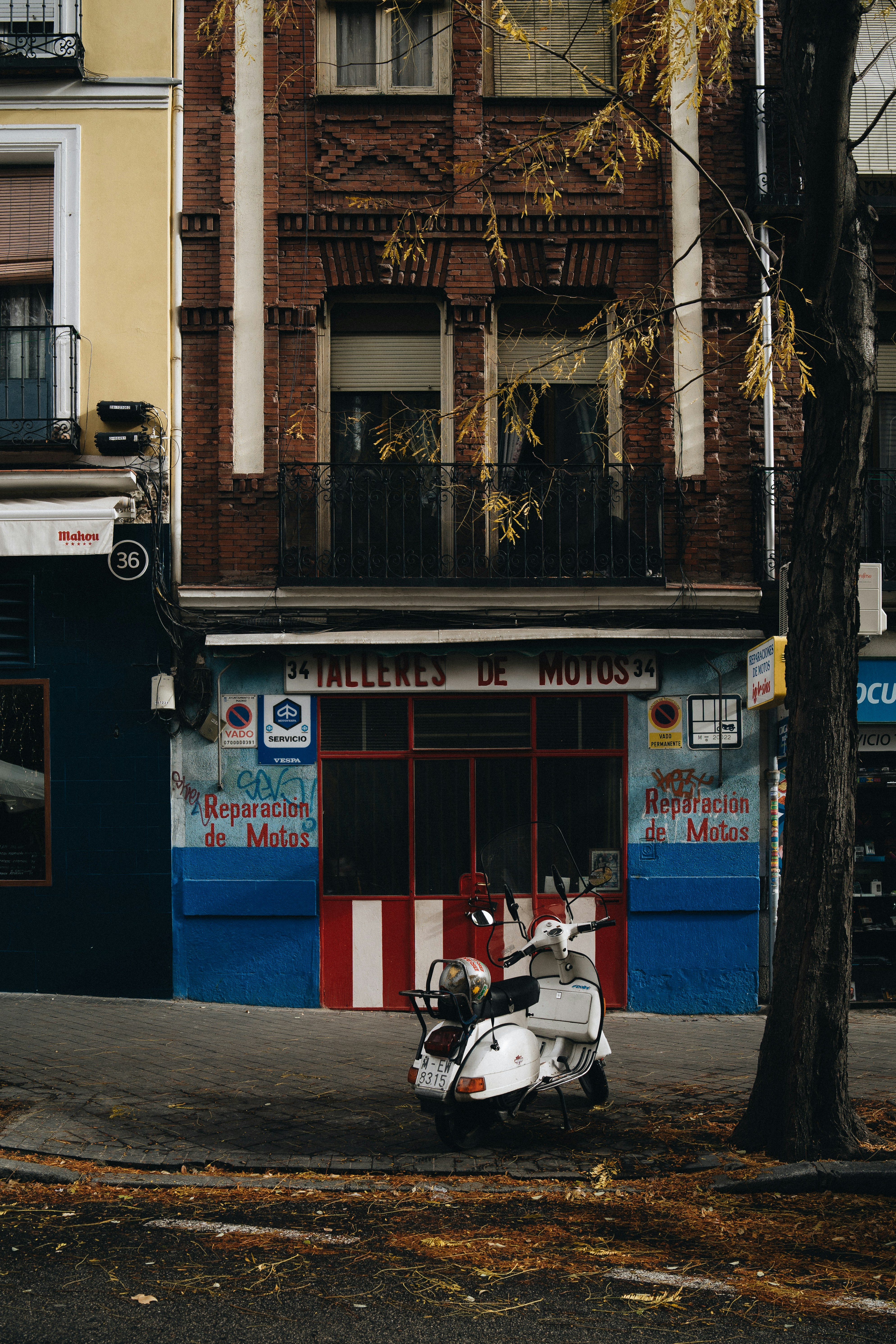 white motor scooter parks in front of store