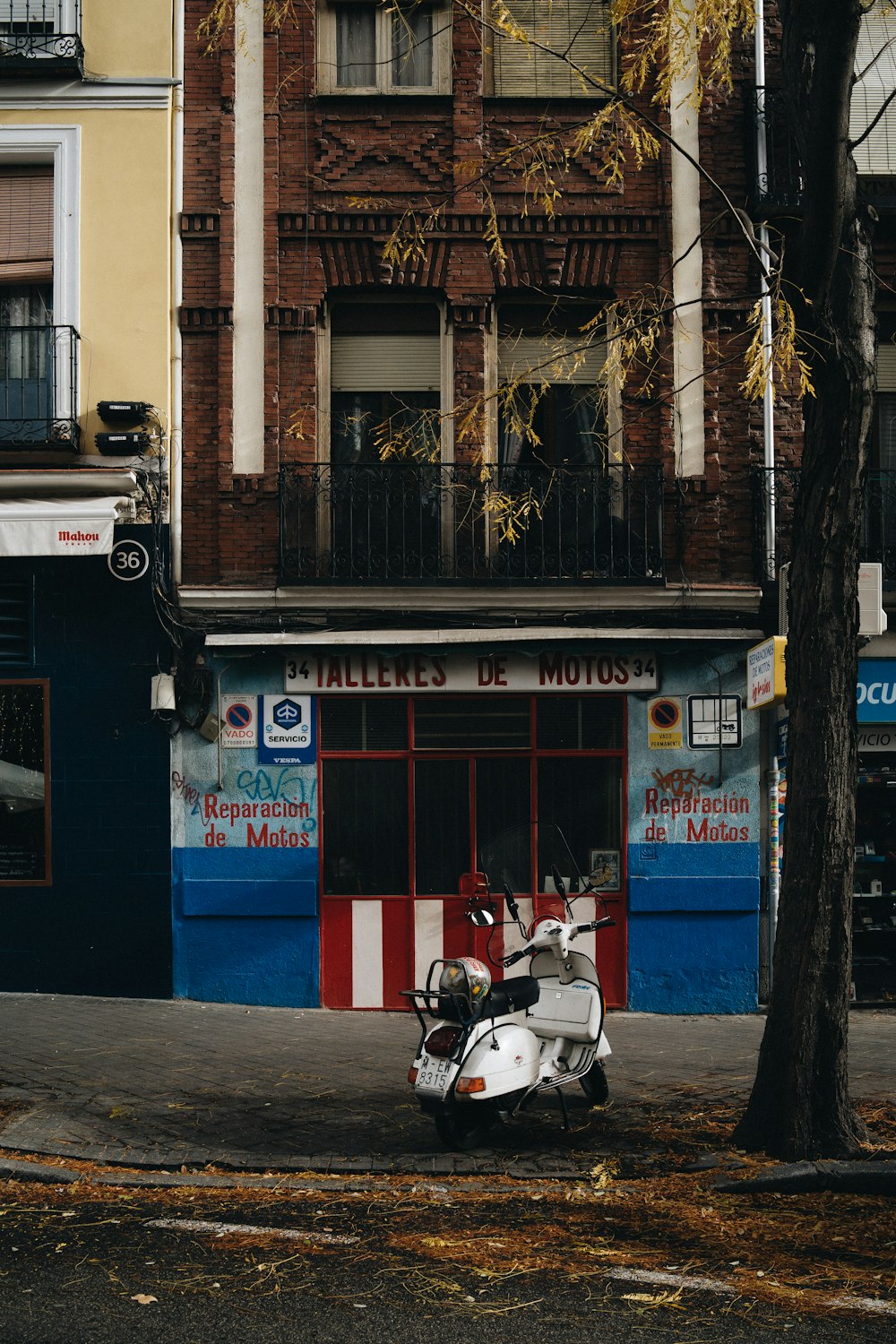 white motor scooter parks in front of store