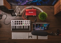 gray and black audio amplifier, silver iPad, microphone, and wireless keyboard