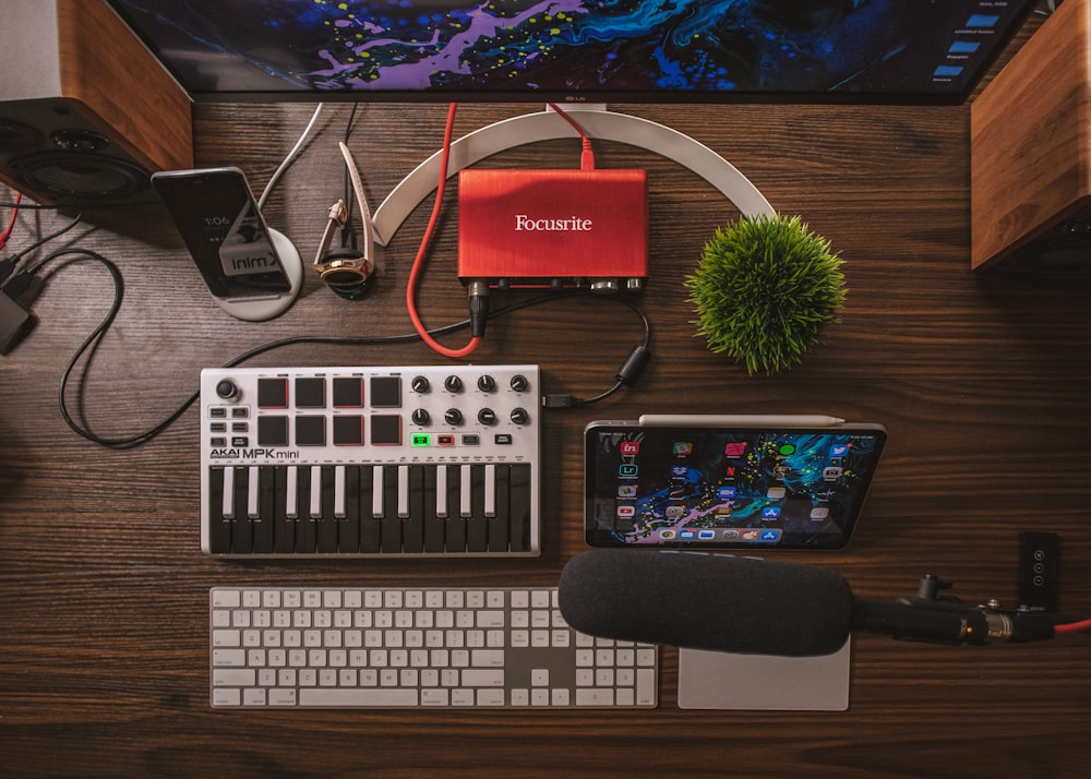 amplificador de áudio cinza e preto, iPad, microfone e teclado sem fio prateados