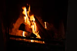 Fireplace crackling inside a cabin with comfortable seating around.