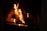 A cozy living room with a crackling fireplace filled with glowing logs.