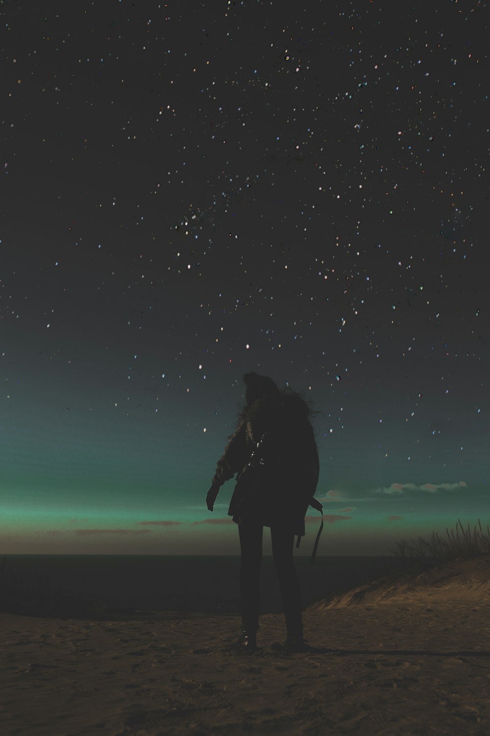 person standing on sand during nighttime