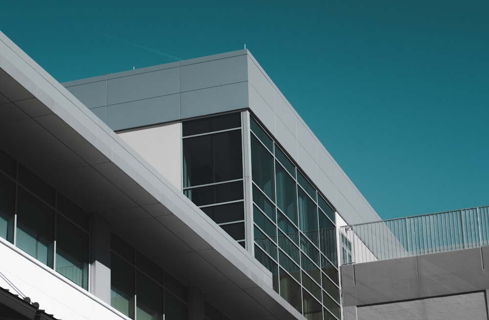 Ventana de vidrio de edificio de hormigón blanco bajo cielo azul