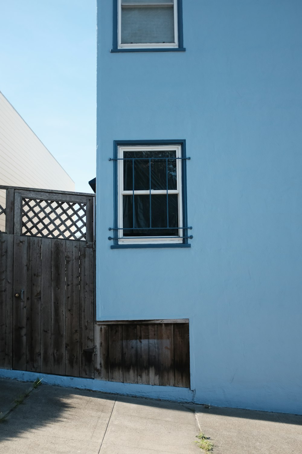 Edificio pintado de azul con ventana de vidrio enmarcada en blanco