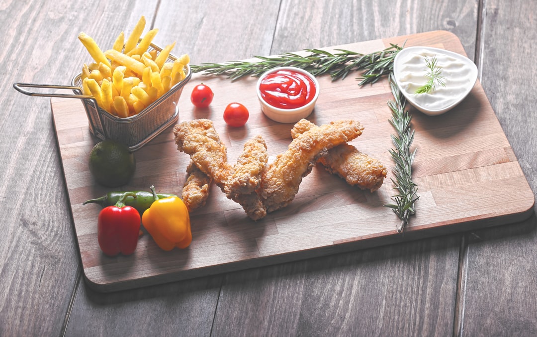 fried food beside fries and vegetables on chopping board