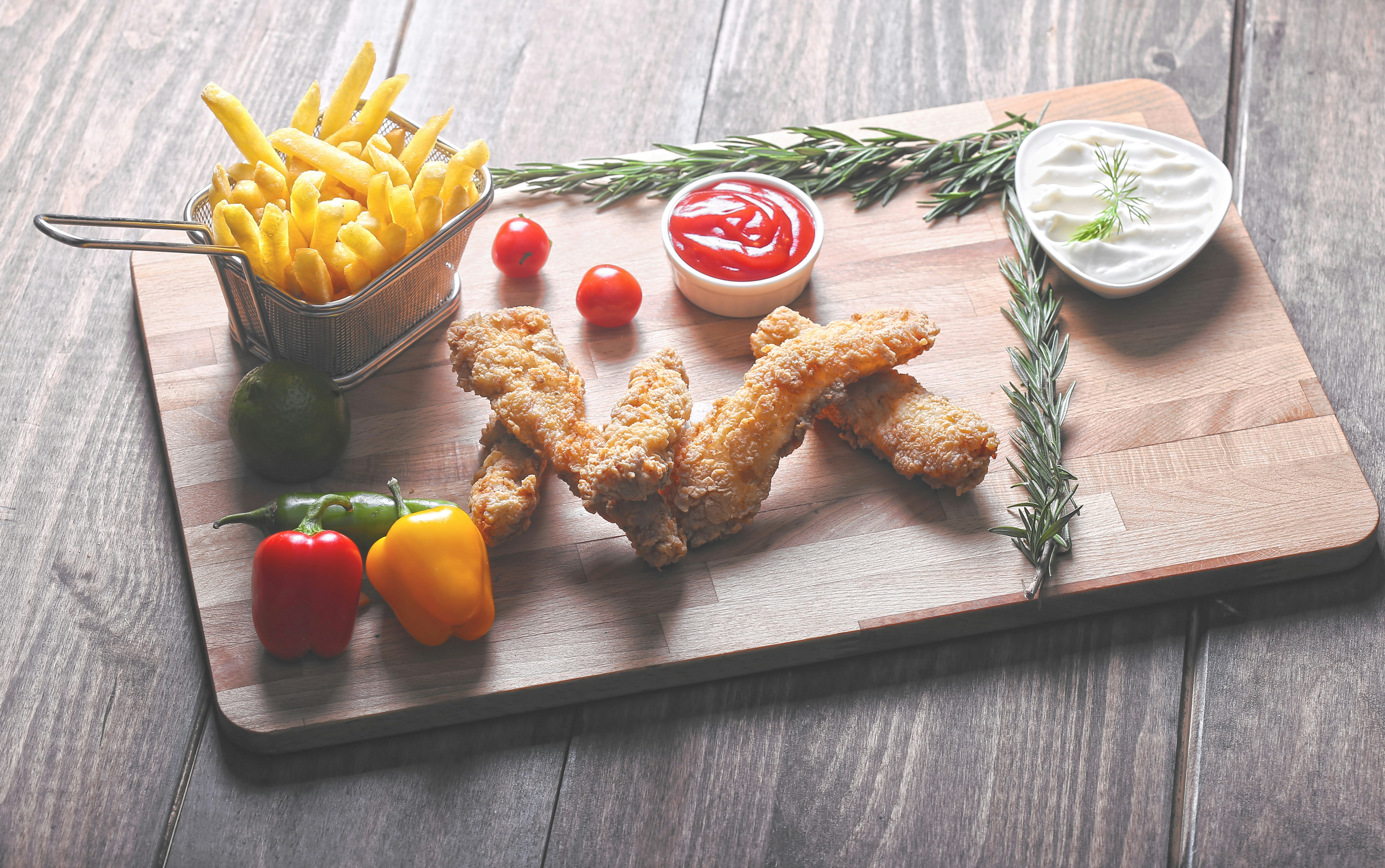 fried food beside fries and vegetables on chopping board