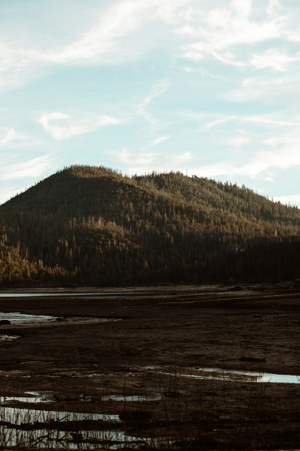 body of water near mountain during daytime