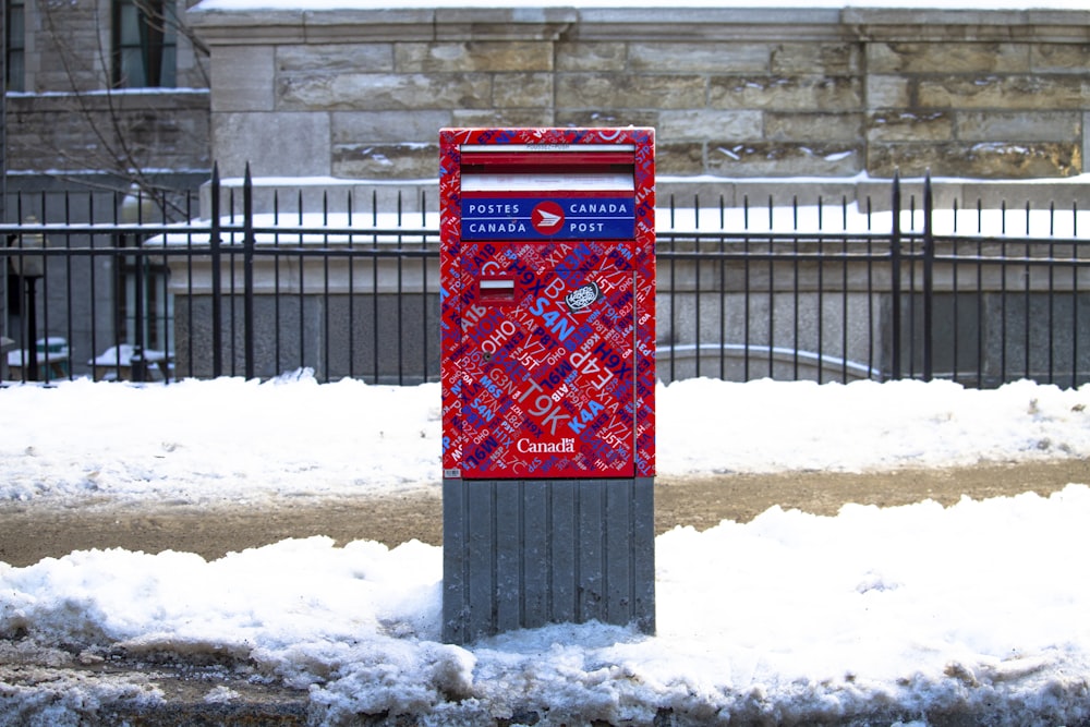 red and gray sign board surrounded with snow