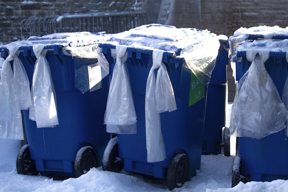 Tres cubos de basura azules al aire libre durante el día