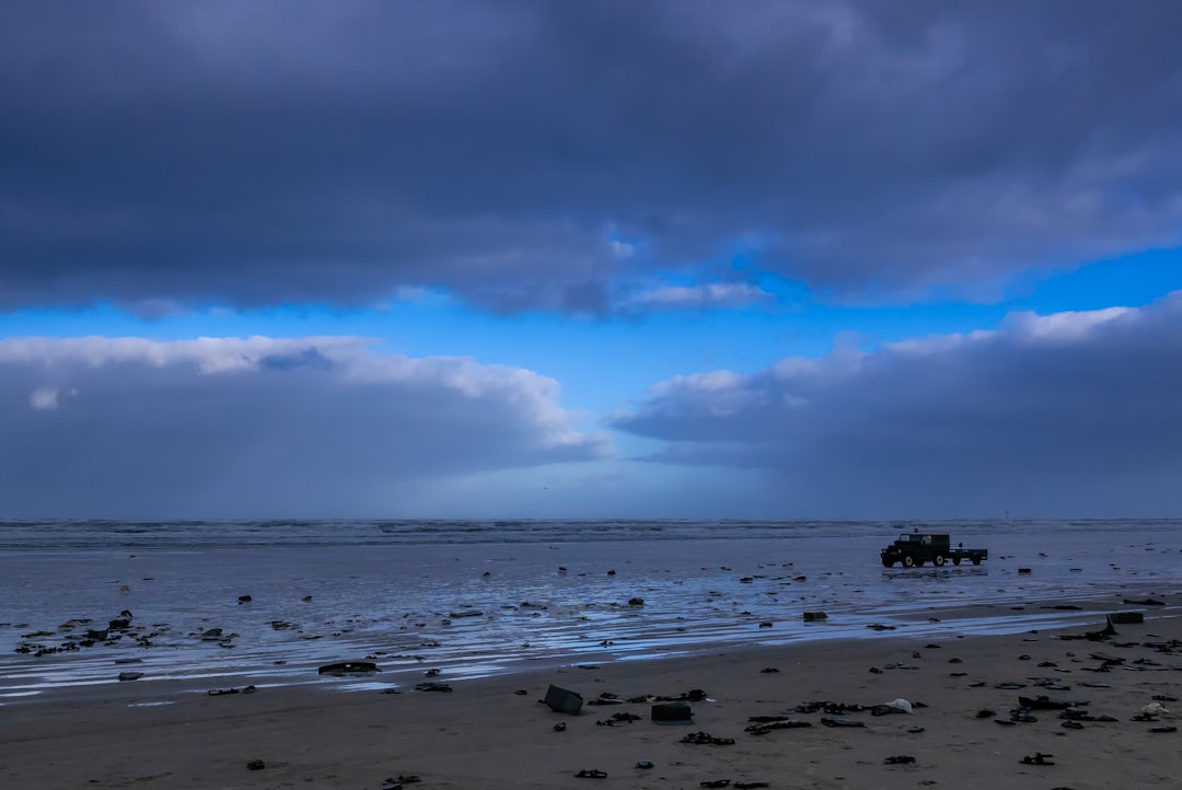 beach under blue and gray sky,