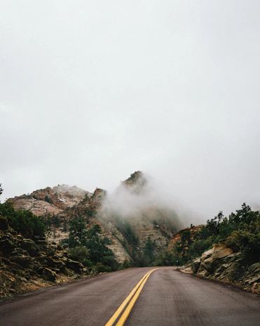 A winding mountain path disappearing into the mist, inviting exploration.